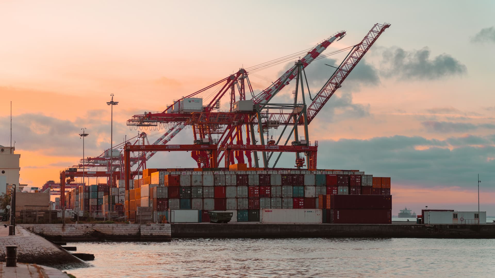 Container ship alongside cranes at a commercial port