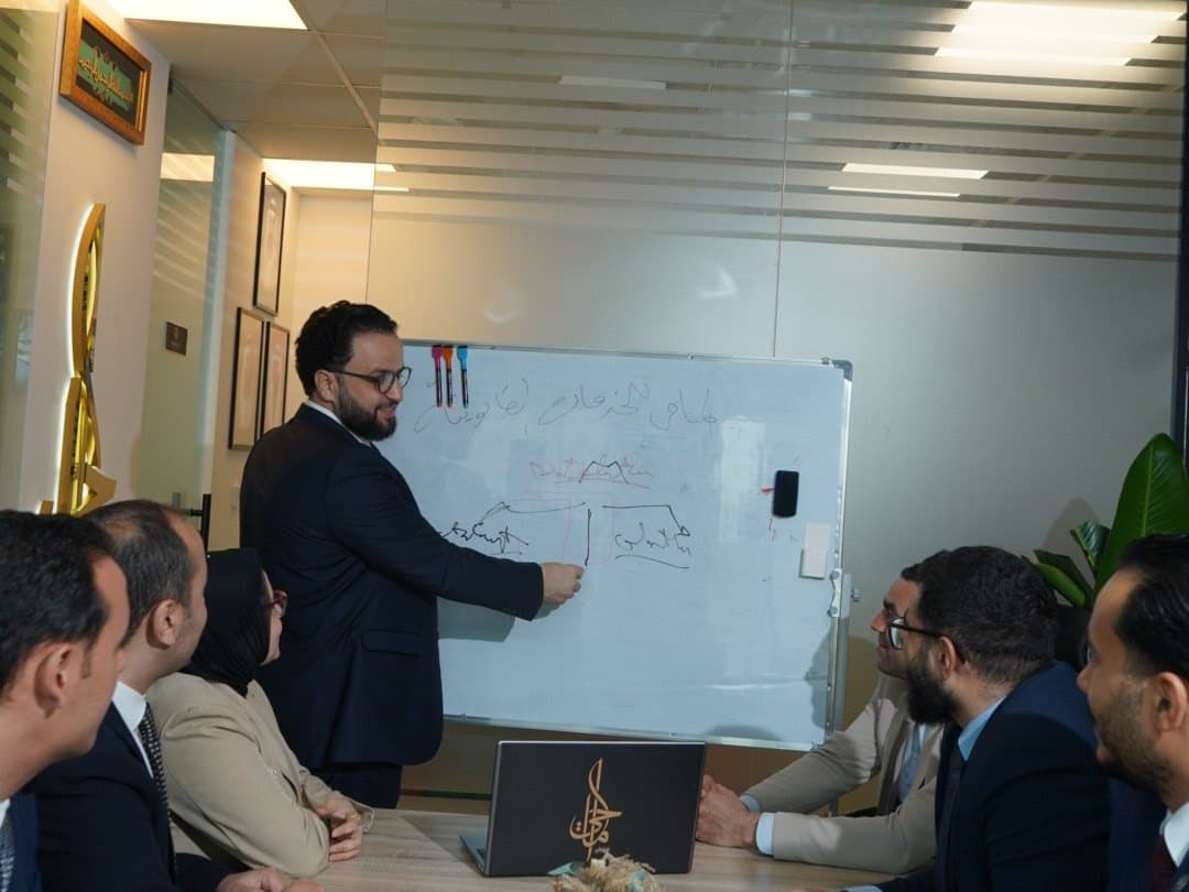 Advisors working through figures on a whiteboard